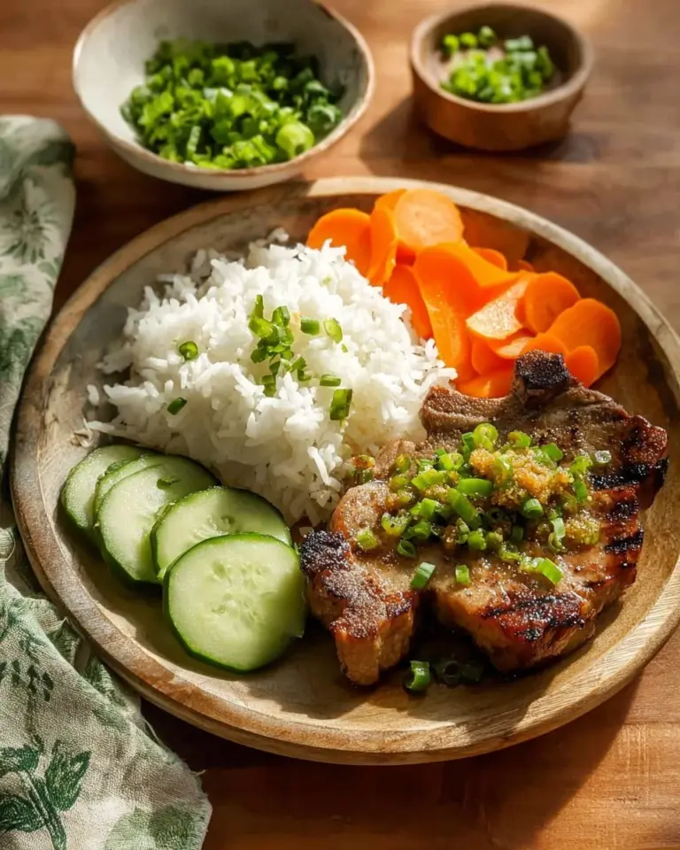Plate of classic Vietnamese Pork Chops garnished with fresh herbs and vegetables.