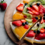 Colorful fruit pizza topped with assorted fresh fruits on a sweet crust