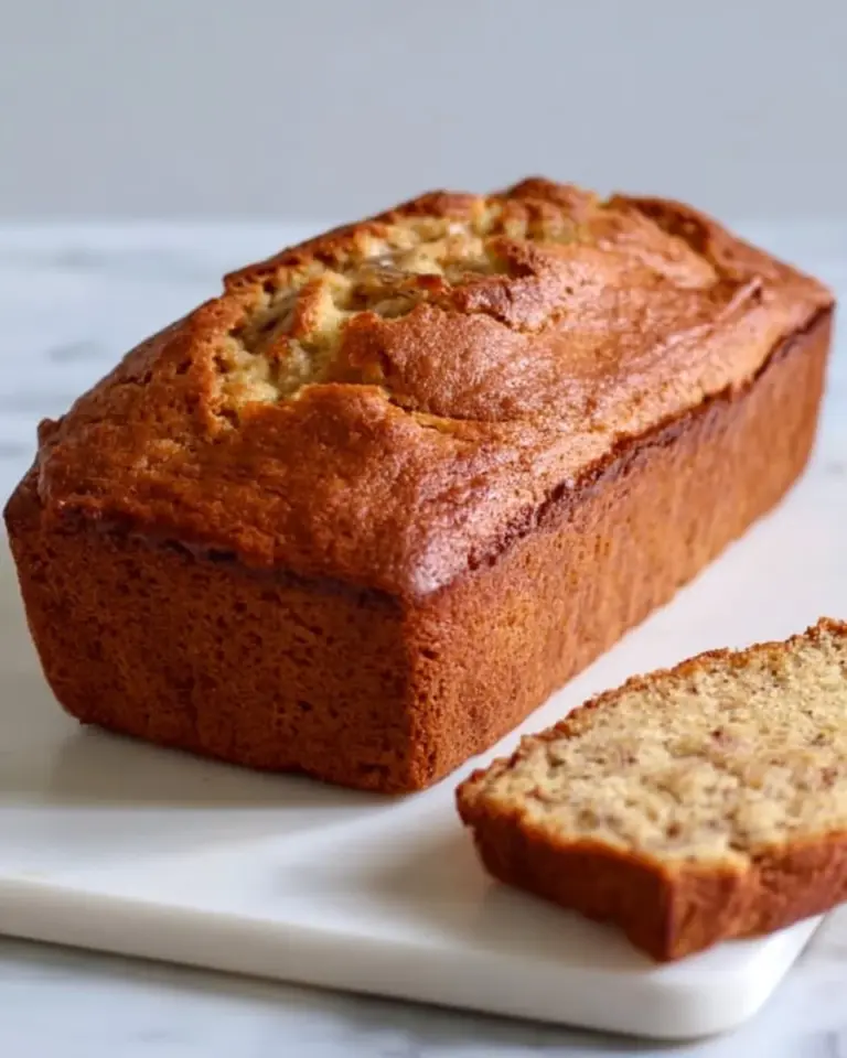 Slice of gluten-free banana bread on a wooden cutting board